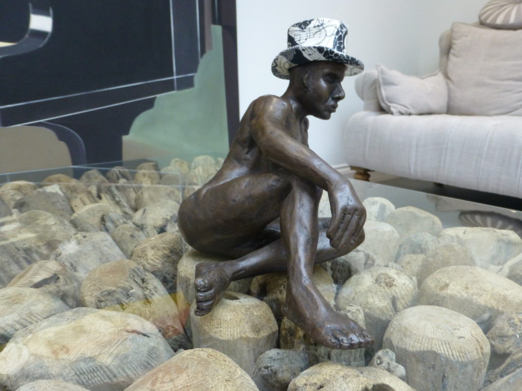 Matthew in bronze sitting on a glass coffee table